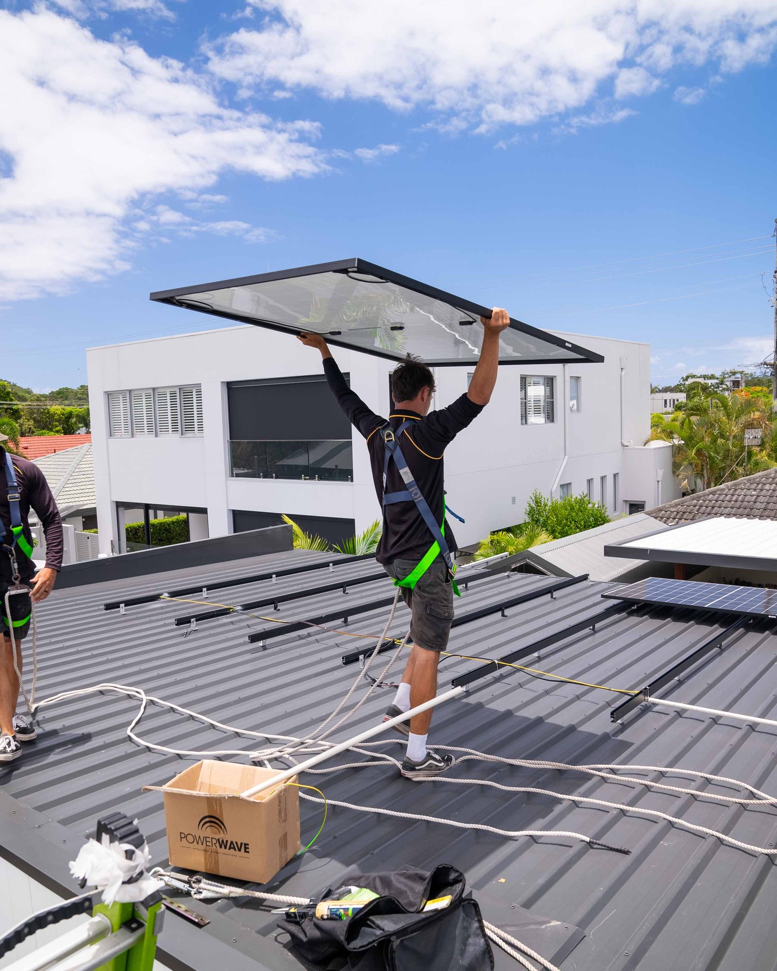 Vivid Electrical team carrying panels on site